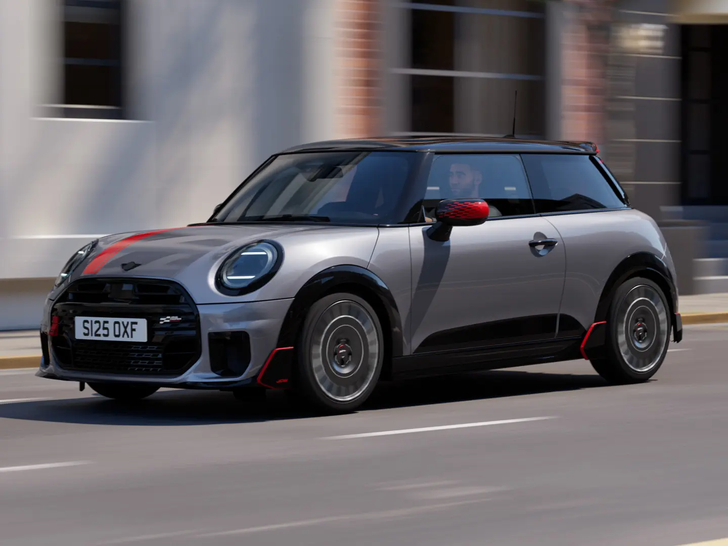 MINI Cooper 3도어 (멜팅 실버), 존 쿠퍼 웍스 미러 캡 및 보닛 데칼 (칠리 레드), 루프 스포일러 및 윙렛 (블랙), 도시 도로를 따라 달리는 모습 - 전면 전망.