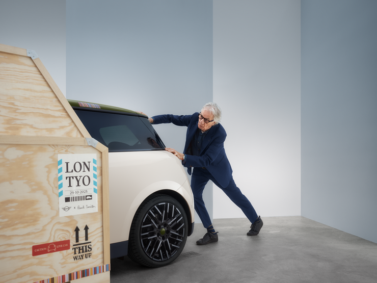 Back view of the all-electric MINI Cooper Paul Smith Edition in Inspired White with Paul Smith behind the car.