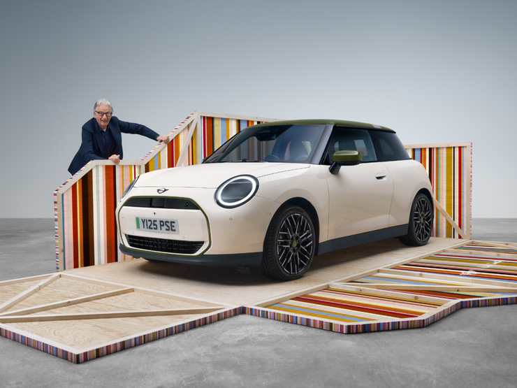 Front side view of the all-electric MINI Cooper Paul Smith Edition in Inspired White with designer Paul Smith.
