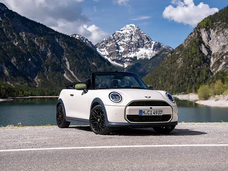 Back view of the all-electric MINI Cooper Paul Smith Edition in Inspired White with Paul Smith behind the car.