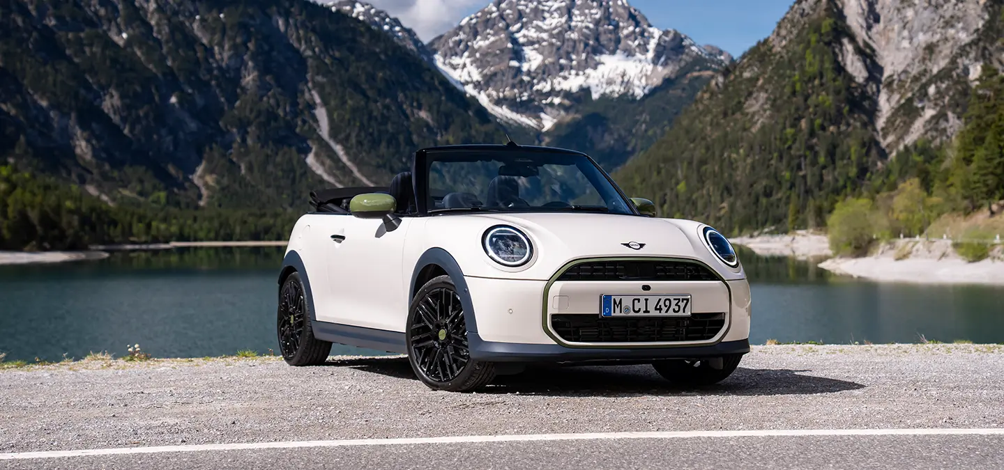 Back view of the all-electric MINI Cooper Paul Smith Edition in Inspired White with Paul Smith behind the car.
