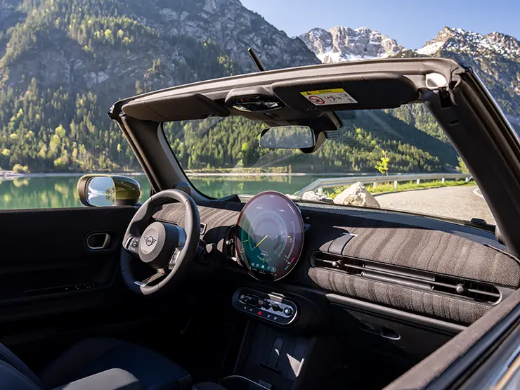 Side interior shot of the all-electric MINI Cooper Paul Smith Edition with Paul Smith looking into the car.