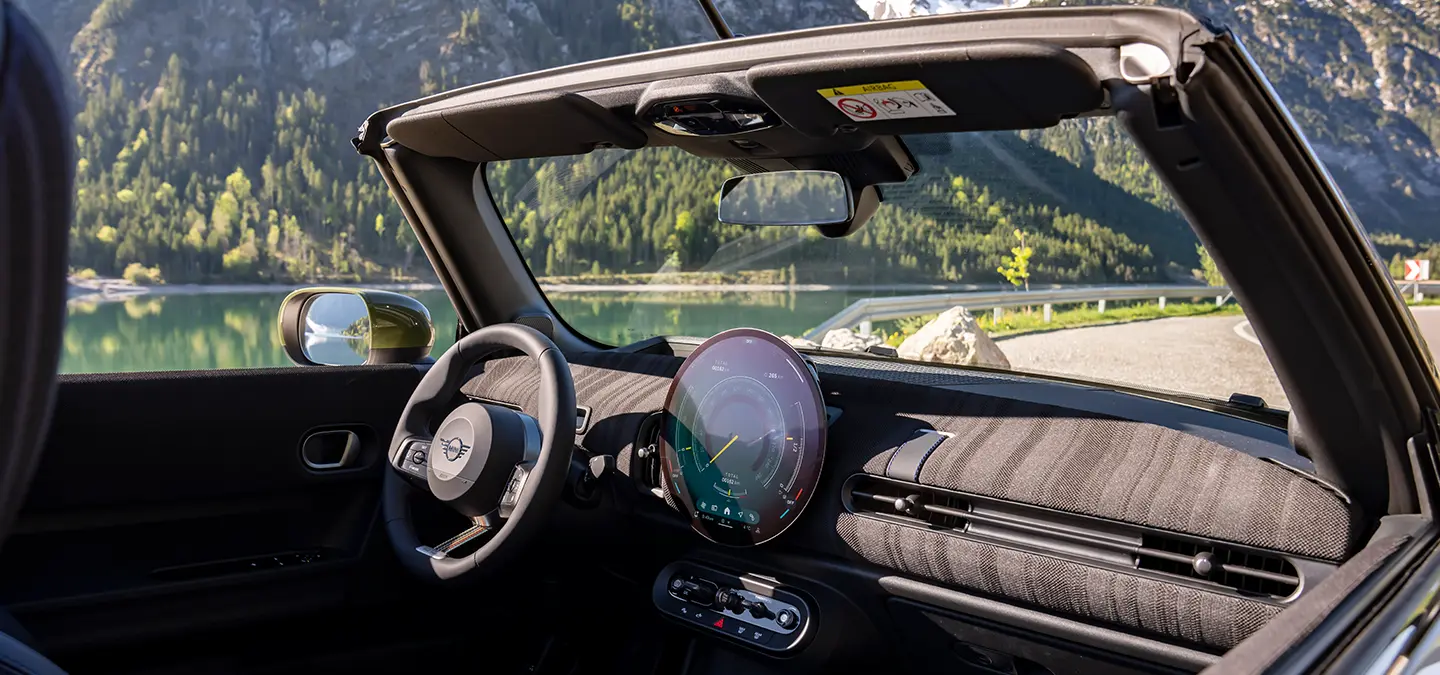 Side interior shot of the all-electric MINI Cooper Paul Smith Edition with Paul Smith looking into the car.